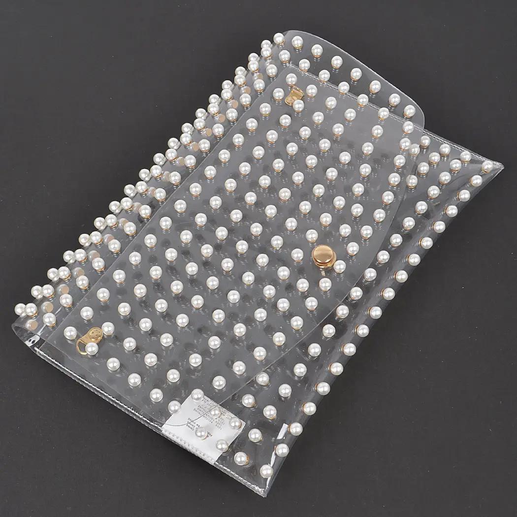 Clear clutch with pearls against black background