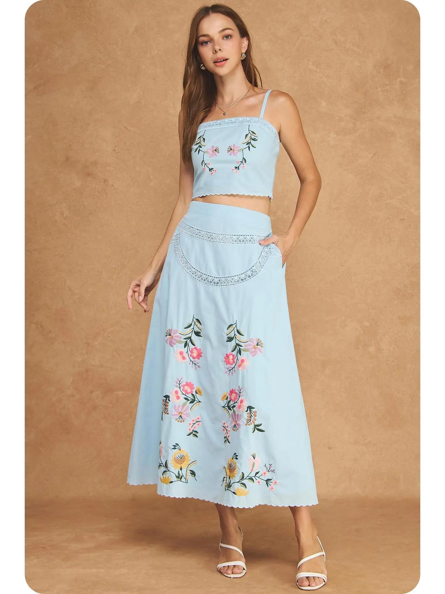 Woman wearing blue two piece with floral details. 