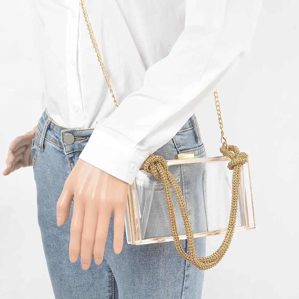 Mannequin wearing clear bag with rhinestone handle as a crossbody. 