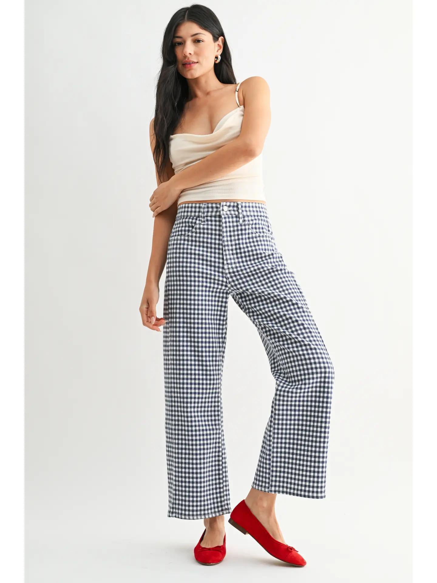 Woman wearing a white tank top gingham navy jeans and red ballet flats. 