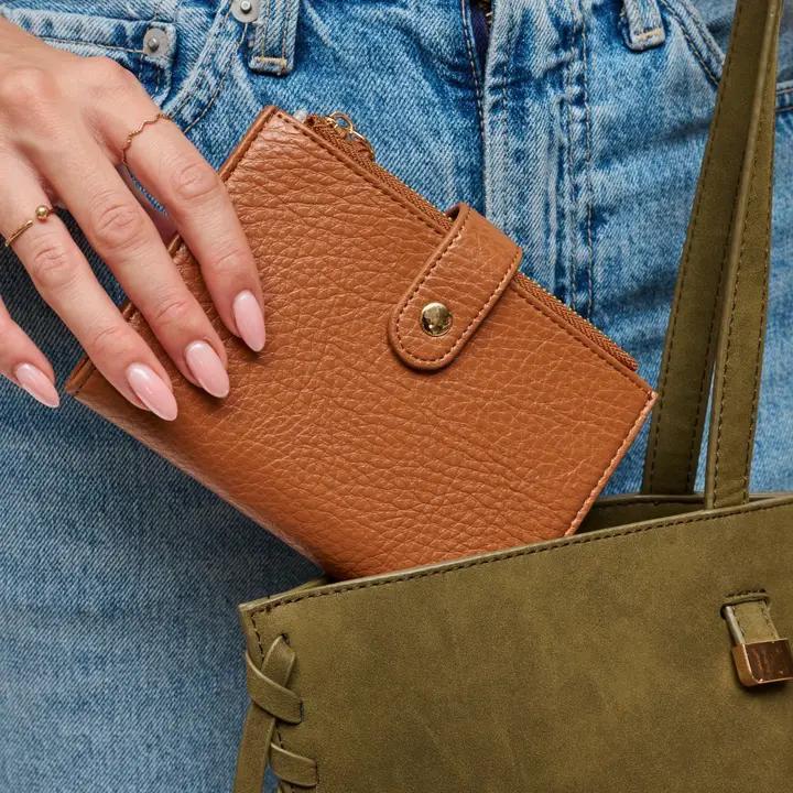 Hand holding warm brown wallet. 