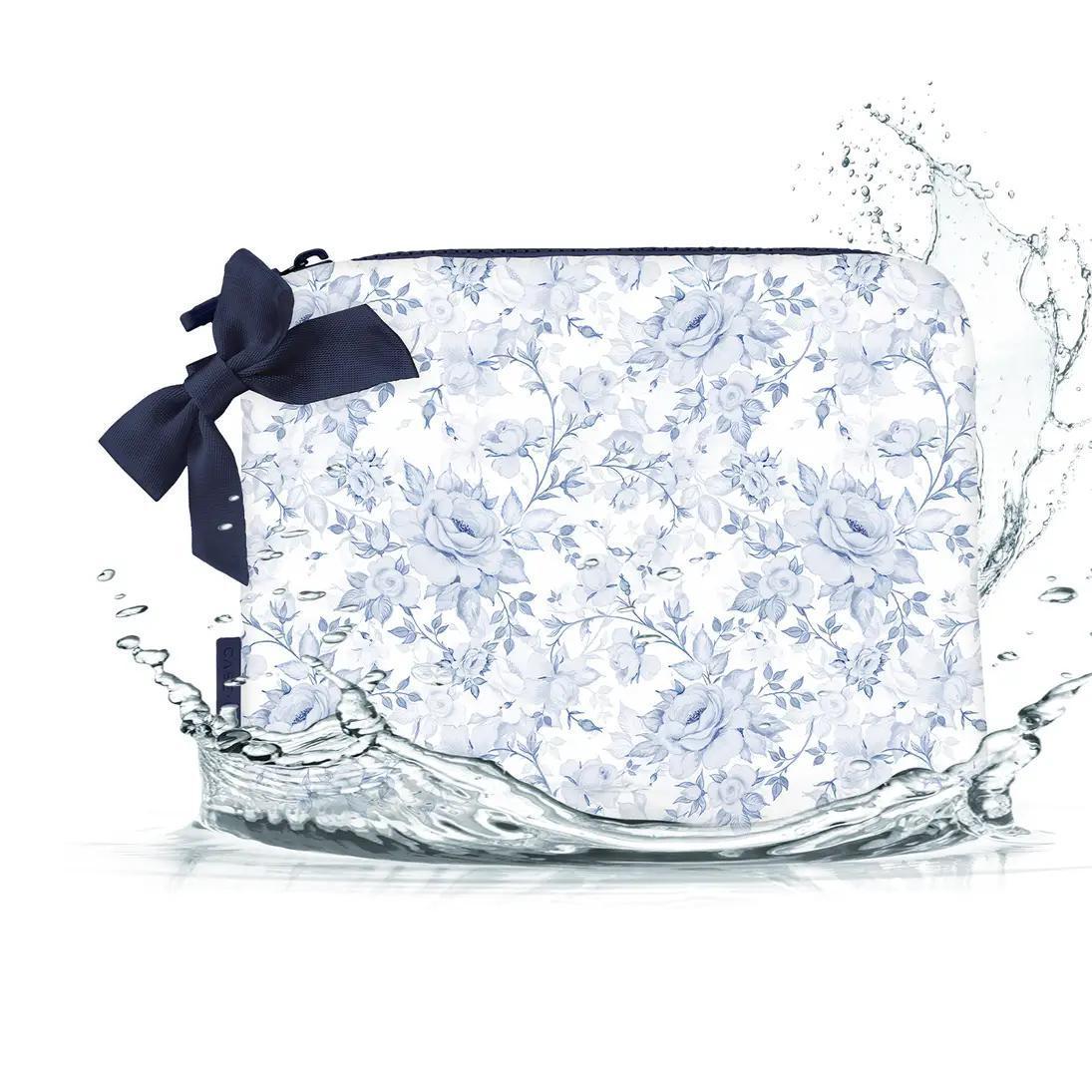 Makeup bag with blue and white details and blue bow sitting in water to prove waterproof. 