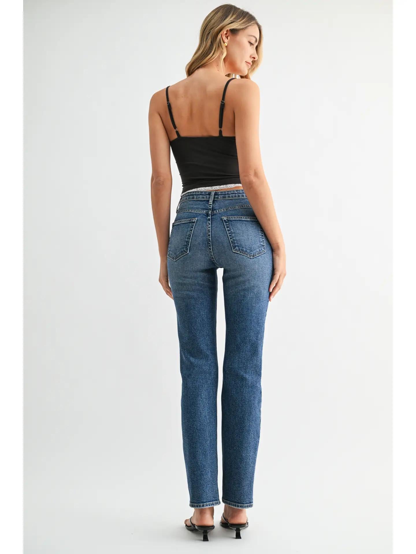 A dark wash straight high rise jeans worn with a two tone tank top and kitten heels. 