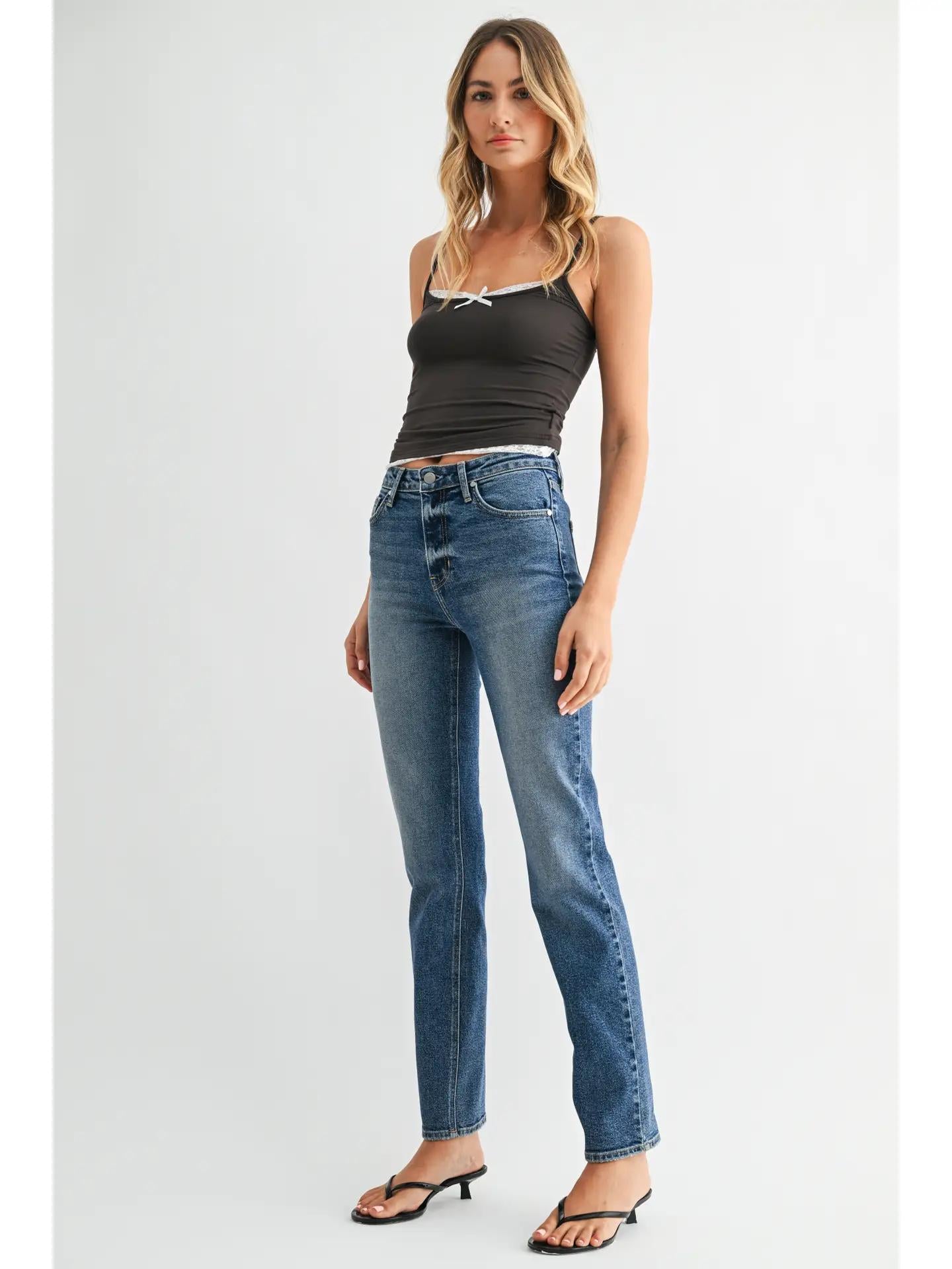 Dark wash skinny straight leg jeans with a grey and white tank top and black sandal heels. 